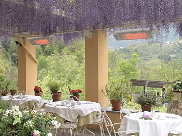 Heatscope Heaters Spot 2800W Radiant Heater wall-mounted on an outdoor restaurant terrace providing electric infrared heat.